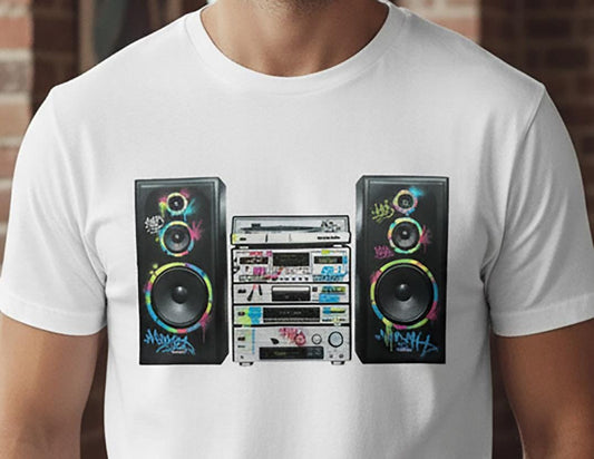 White t-shirt with a colorful graphic of a Hi-Fi system and speakers on a brick wall background.