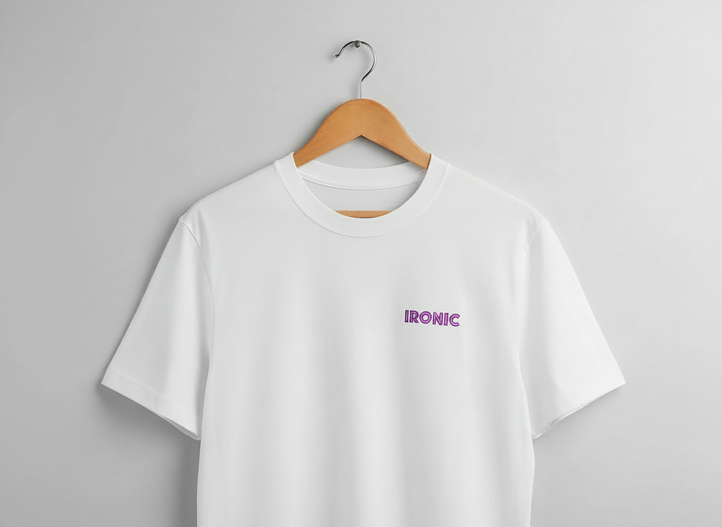 White t-shirt with 'IRONIC' logo on a hanger against a gray background