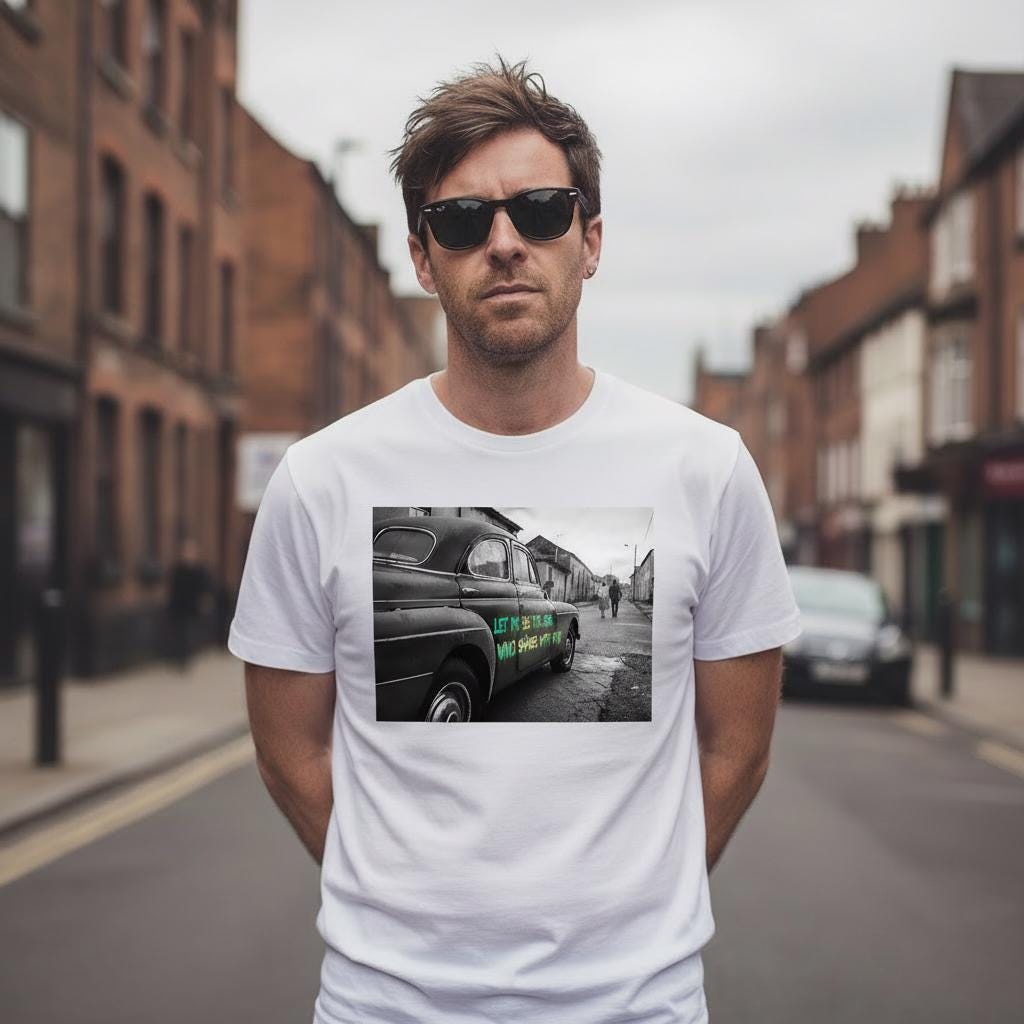 Man wearing a white t-shirt with a graphic design of a vintage car on a street.